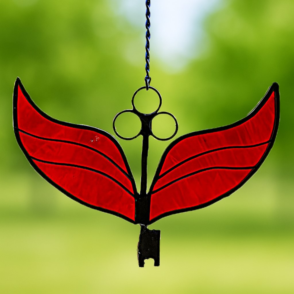 Stained glass winged key in deep red tones, fantasy-style suncatcher with crimson glass wings and antique design